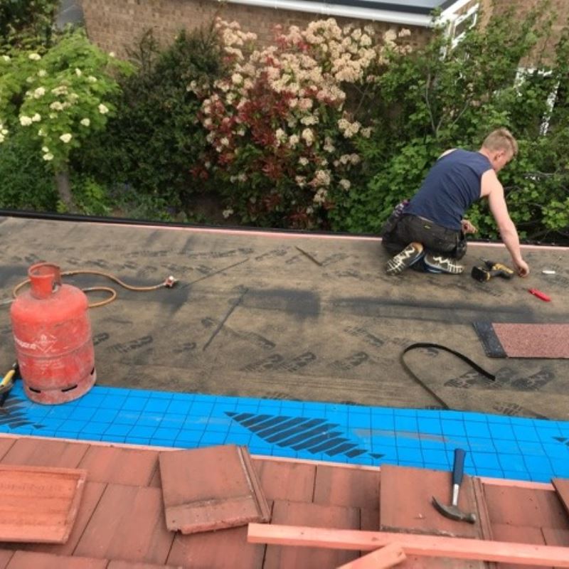 man on flat roof working